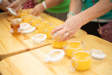Honey in a jar. A man is packing honey. A woman pours the sweet into the jar. Gifts of nature.