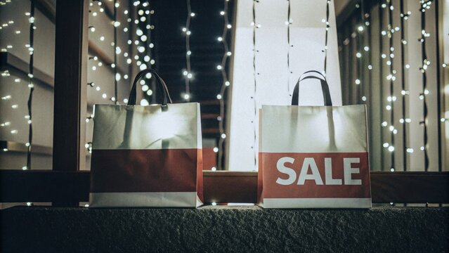 Festive night: shopping bags with sale sign and string lights decor