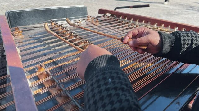 Street performer playing Iranian Santoor musical instrument, slow motion