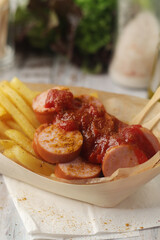 Currywurst lightly topped with curry and served with chips	