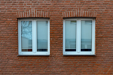 two white windows on a clinker-brick house facade