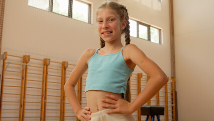 Young girl Caucasian kid child teen female daughter pupil student school sport lesson education gymnasium class studying posing glad smiling happy schoolgirl gymnast dancer acrobat athlete sportswoman