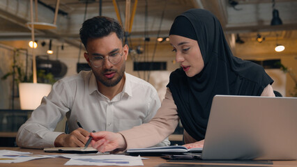 Two business colleagues muslim islamic businesswoman in hijab Arabian businessman working with...