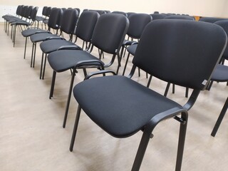 Obraz premium Black soft office chairs with backs stand in empty room before event