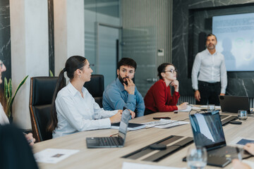 A diverse group of coworkers engage in a productive brainstorming session, sharing and discussing innovative ideas in a modern office setting with laptops and presentations.