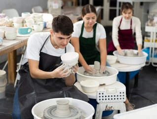 Young man holding finished pottery made on potter's wheel