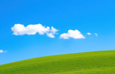 Obraz premium Rich green hill under clear blue sky with white clouds. Idyllic rural landscape. Perfect day for outdoor activities. Picturesque meadow pasture. Natural beauty with vibrant colors. Scenic view.