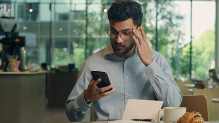 Indian business man guy Arabian businessman male user visitor in cafe hope wish hold mobile phone...