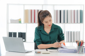 Focused Businesswoman: A focused businesswoman working diligently at her desk, showcasing dedication and professionalism in a modern office setting.