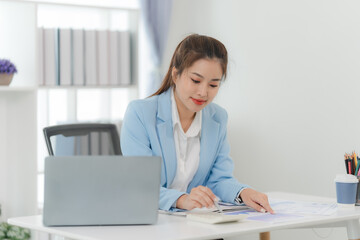 Focused and Confident: A professional woman analyzes financial data with a determined gaze, radiating confidence and competence. Her posture and expression exude focus and engagement.