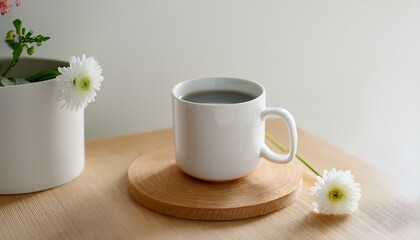 Coffee in a neatly designed mug with a small flower next to it