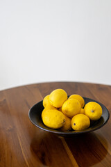 Fresh Lemons in a Black Bowl on Wooden Table