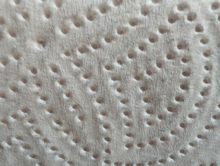 Close-up macro view of white embossed kitchen paper towel texture details with circular patterns...