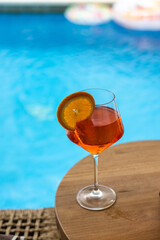 Refreshing tropical drink served in a glass with vibrant garnishes, placed poolside against a luxurious background. The image captures a relaxing vacation vibe, perfect for promoting travel, leisure, 