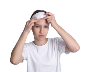 Teenage girl popping pimple on her face against white background. Acne problem
