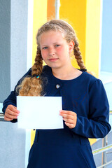  girl holding  paper .   girl in a  uniform. pupil, learner, scholar.  schoolgirl. Copy space