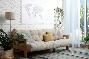 Stylish living room interior with comfortable sofa near white brick wall