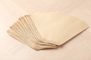 Paper coffee filters on light wooden table