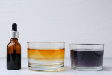Iodine starch test. Bottle of iodine, glass with water containing starch and regular one on white table