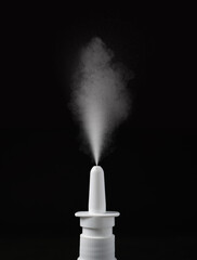 Nasal spray with sprinkled medication over nozzle on black background, closeup