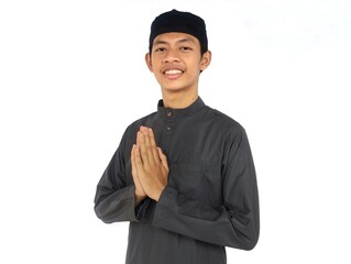 Moslem Asian man smiling friendly when doing greeting pose