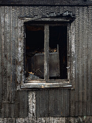 Charred wooden wall of burnt building, fire aftermath