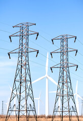 Power line towers with wind turbines in the background, highlighting the integration of renewable energy sources into the electrical grid, craft clay, with white tones