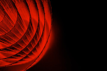 Abstract spiral with glowing red wire texture against a black background, symbolizing color contrast, energy, motion, industrial and futuristic design concepts. Copy space