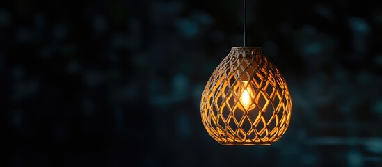 Fototapeta premium Unique hanging lamp illuminating a dark background highlighting intricate craftsmanship and elegant design details suitable for interior decor.