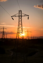 Electricity and saving energy concept. Power supports at sunset on backdrop in blur., dinamic scene, with white tones