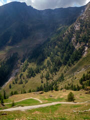 Fototapeta premium Mountain trails with valley views and dark cloud sky, Piamprato, Valprato Soana, Gran Paradiso National Park