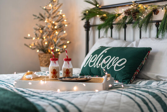 Milk and cookies on a tray in a sunny bedroom decorated for Christmas