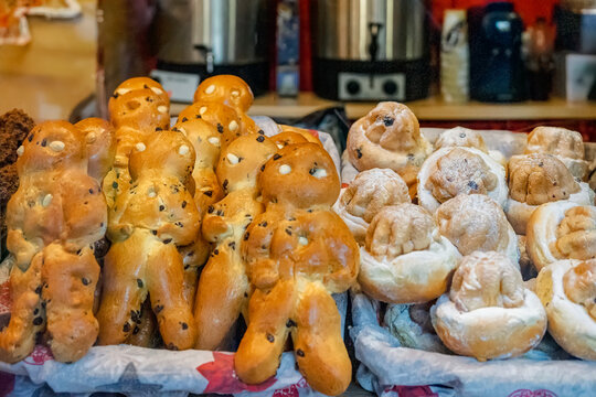 Traditional bread shaped like man figurines with raisins, rolls in Christmas market. Concept of festive baked goods