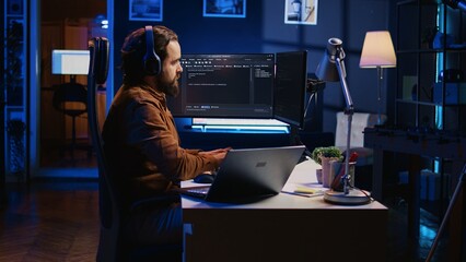 Developer focused on typing complex code in neon lit home office, listening music and developing...