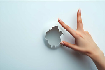 closeup of female hand coming out from a hole in a paper okay sign on white background commercial photo stock photo soft light light photo