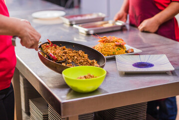 Chefs preparing traditional Chaulafan con marisco ecuadorian food in a restaurant kitchen