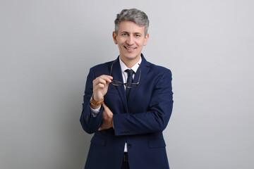 Portrait of businessman with glasses on light grey background