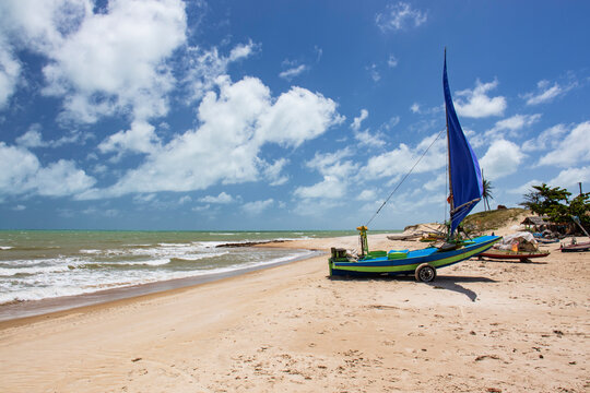 A traditional jangada boat anchored at Perobas Beach in Touros, Rio Grande do Norte, Brazil. This photo captures the coastal life and fishing culture of Northeast Brazil with serene beach views