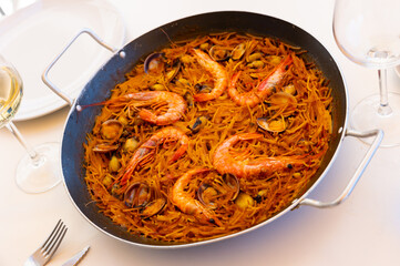 Traditional spanish seafood dish fideua with aioli sauce in a restaurant