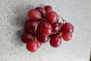 The red grapes are sitting on a table.