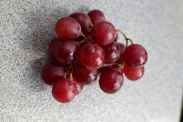 The red grapes are sitting on a table.