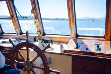 Steering wheel and captain's cabin. Sea ferry, close-up view of the steering wheel. Ship's captain's bridge