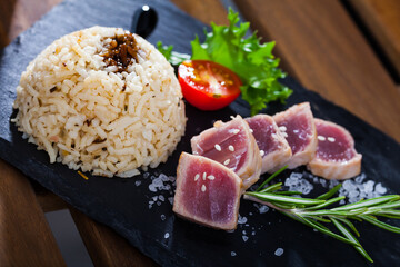 Tasty pan seared sashimi grade tuna (tataki) served with rice, vegetables, greens and soy sauce