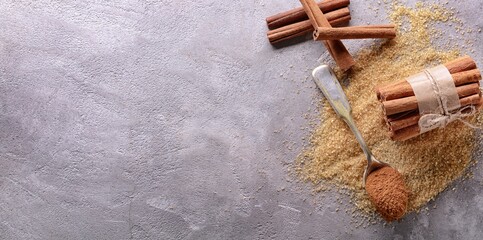 Composition with cinnamon and sugar on grey background with space for text, top view