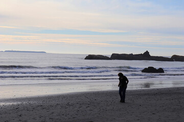 Naklejka premium Walker on the Pacific Beach just before sunset