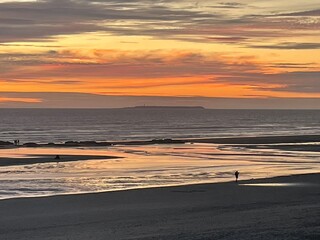 Sunset over the pacific with distant walkers