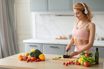 A woman dressed in athletic clothing is chopping vegetables in a contemporary kitchen. She enjoys...