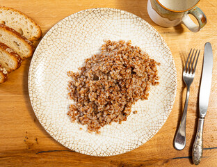 Delicious healthy buckwheat porridge in a plate on the table