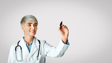 Diagnostics concept. Woman doctor write with marker on virtual board, isolated on light background, studio shot