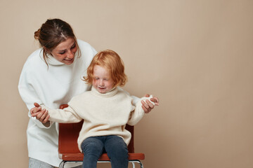 Bonding moment woman and little girl sitting together with hands clasped in family portrait of love and connection